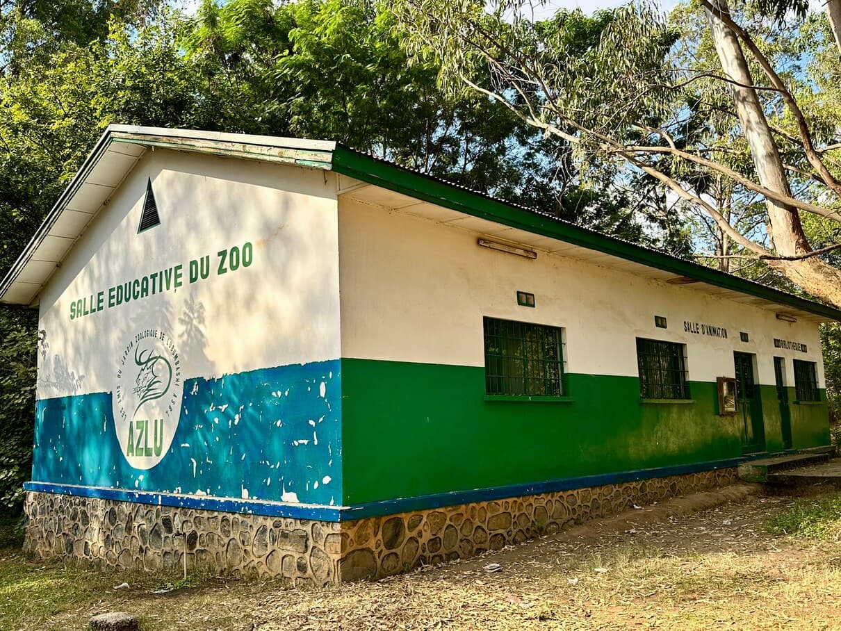 Bâtiment de la salle éducative du zoo, façade blanche, verte et bleue au logo AZLU