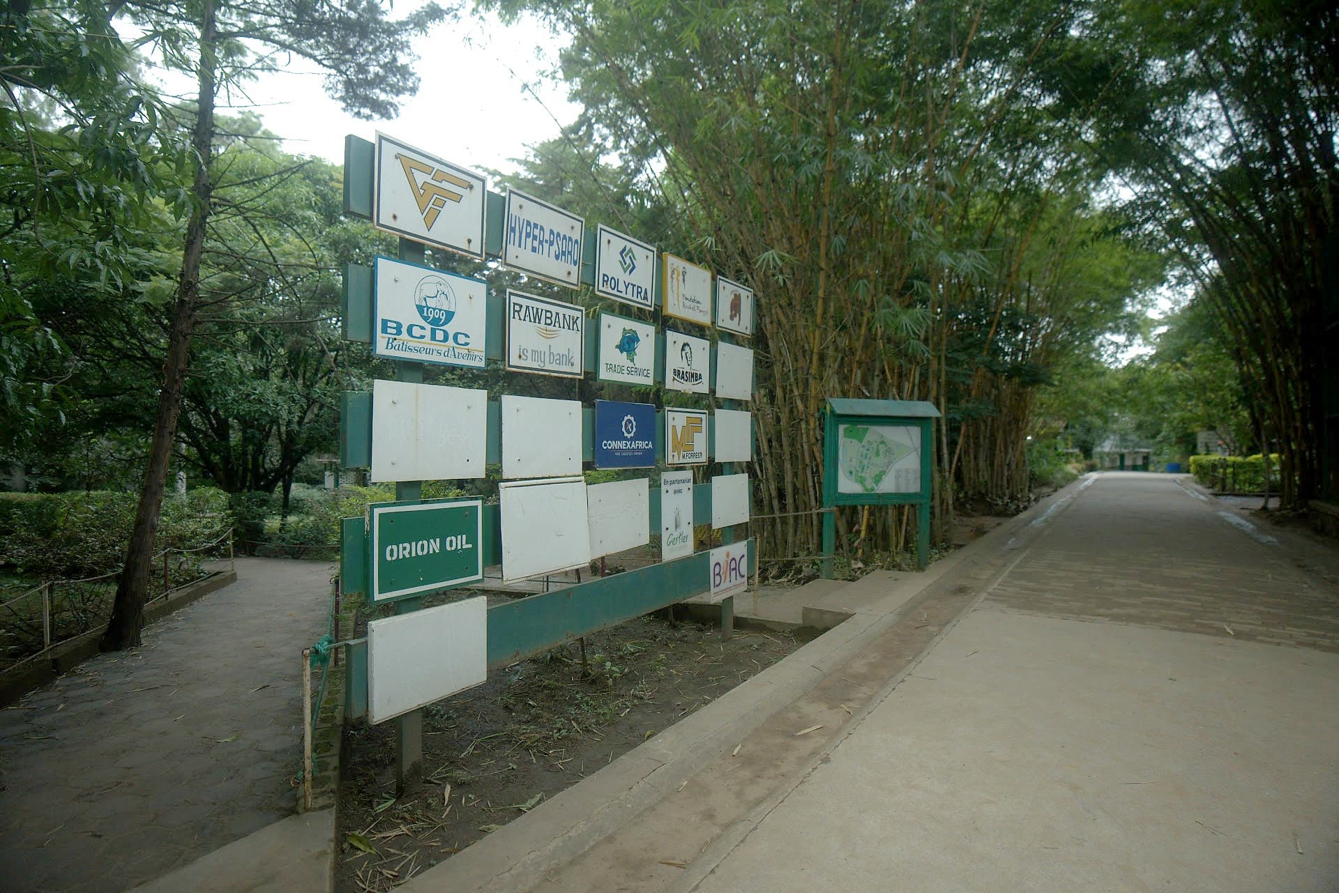 Panneaux des sponsors à l'entrée du zoo, le long de la route bordée de bambous