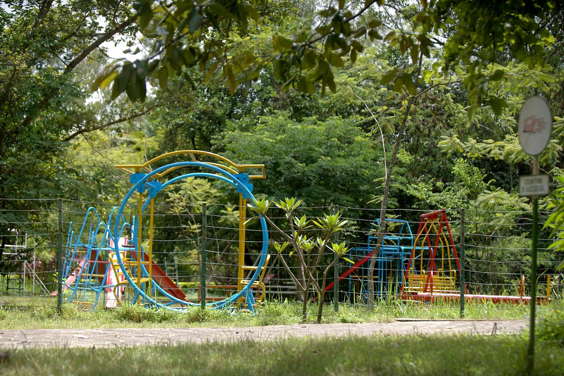 Parc de jeux coloré pour enfants vu depuis le sentier